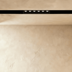 Clérachic recessed grille head lit from below, the six lenses reading as separate points of light.