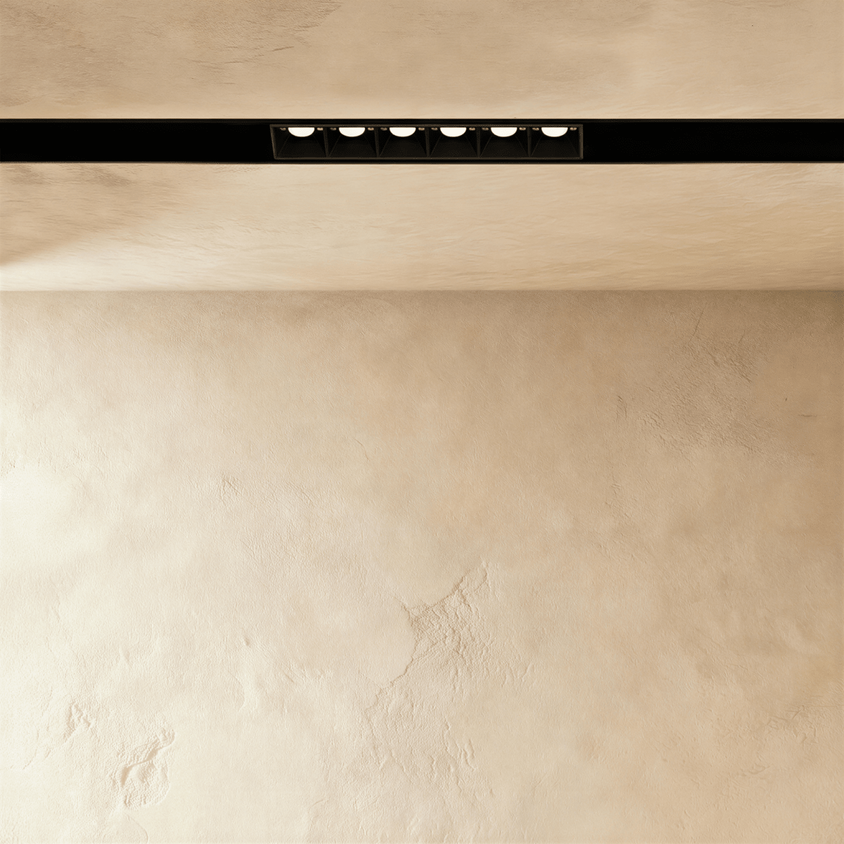 Clérachic recessed grille head lit from below, the six lenses reading as separate points of light.