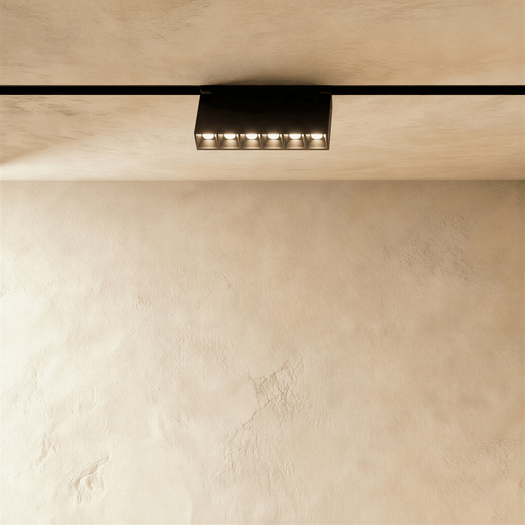 Clérachic surface-mounted grille box, six lenses in a low black housing standing below the rail.