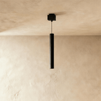 Clérachic pendant head, a slim black cylinder on a thin cable below a square black ceiling box.