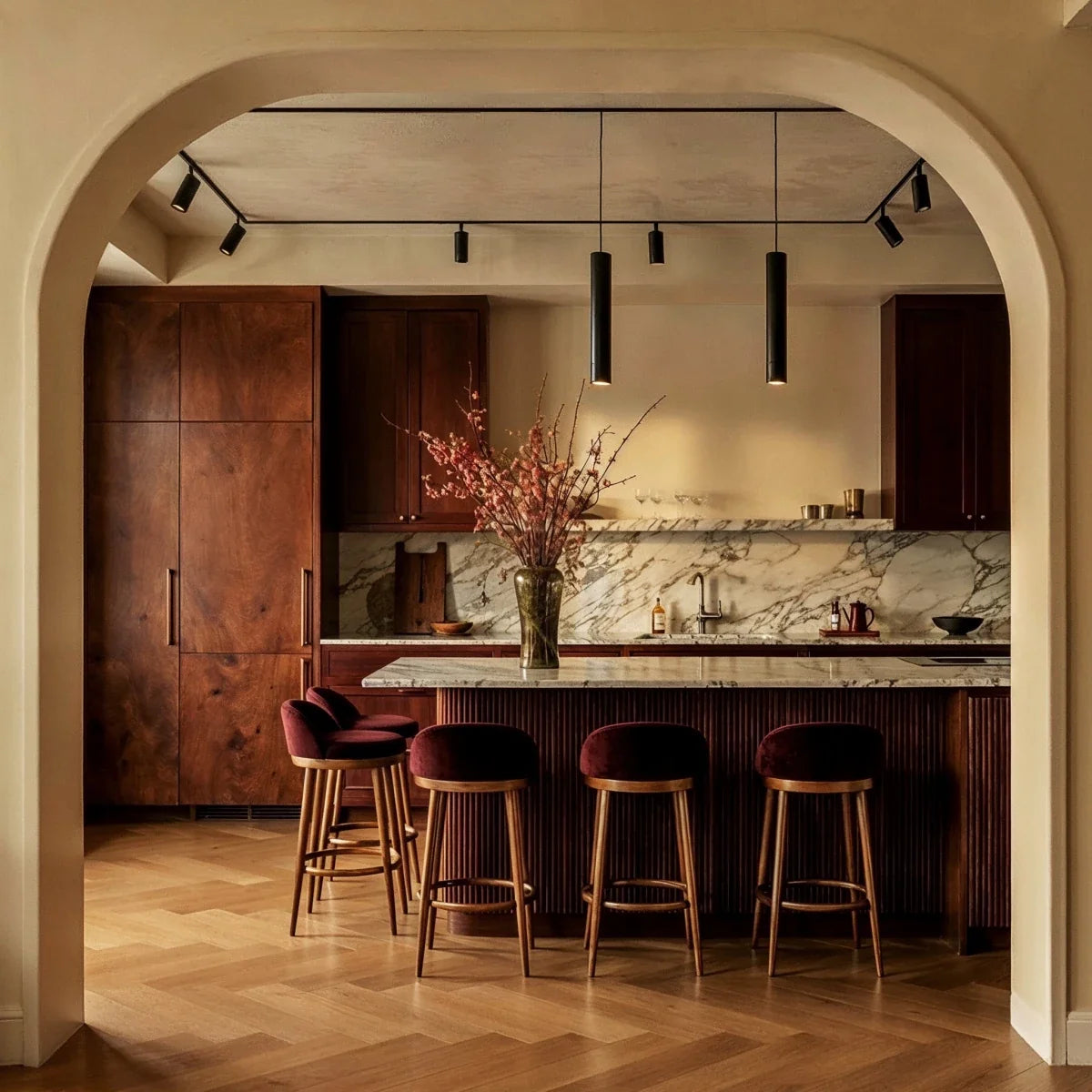 Clérachic track lighting in a kitchen, spotlights and two pendants at different drops above a marble island.
