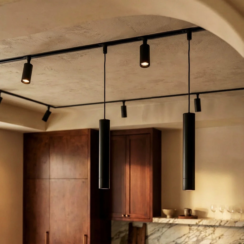 Clérachic track lighting close up, two parallel runs crossing a vaulted ceiling with spotlights and hanging pendants.