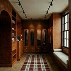 Clérachic track spotlights in a dressing room, one black run lighting glazed wardrobes of hanging clothes.