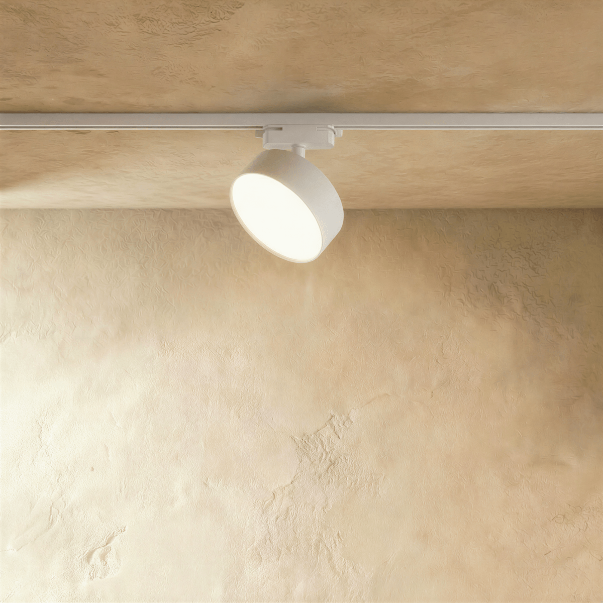 Clérachic white round track light head with a wider drum body on a white rail, lit through a frosted disc diffuser.
