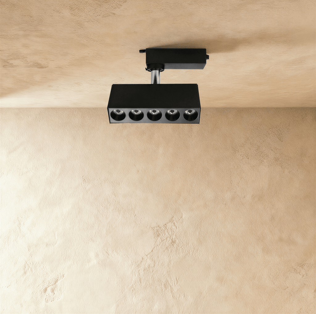 Clérachic black five-spot track spotlight bar with deep recessed round lenses, hanging from a track adaptor on a short stem.