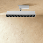 Clérachic long white ten-spot track spotlight bar with black-lined recessed lenses, on a white track adaptor and stem.