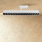 Clérachic extra-long white track spotlight bar with fifteen deep recessed lenses, on a white track adaptor and stem.