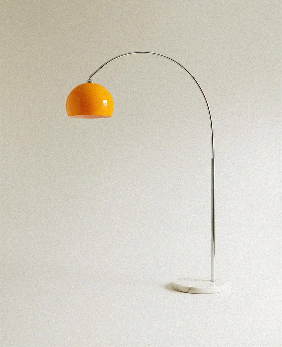 This Clérachic floor lamp pairs a glossy orange dome shade with a slender arc and a round white marble base.