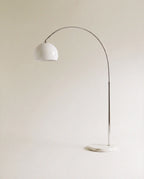 In white, this Clérachic floor lamp curves a slim chrome arm from a marble base to a glossy dome shade.