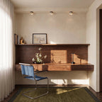 Three Clérachic marble drum ceiling lights in a row above a walnut desk shelf, with a blue cantilever chair below.