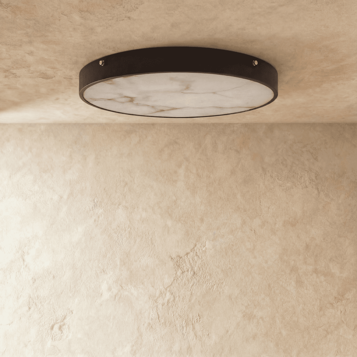 Clérachic flush-mount ceiling light with a veined marble diffuser in a slim dark metal rim, shown on a limewash ceiling.