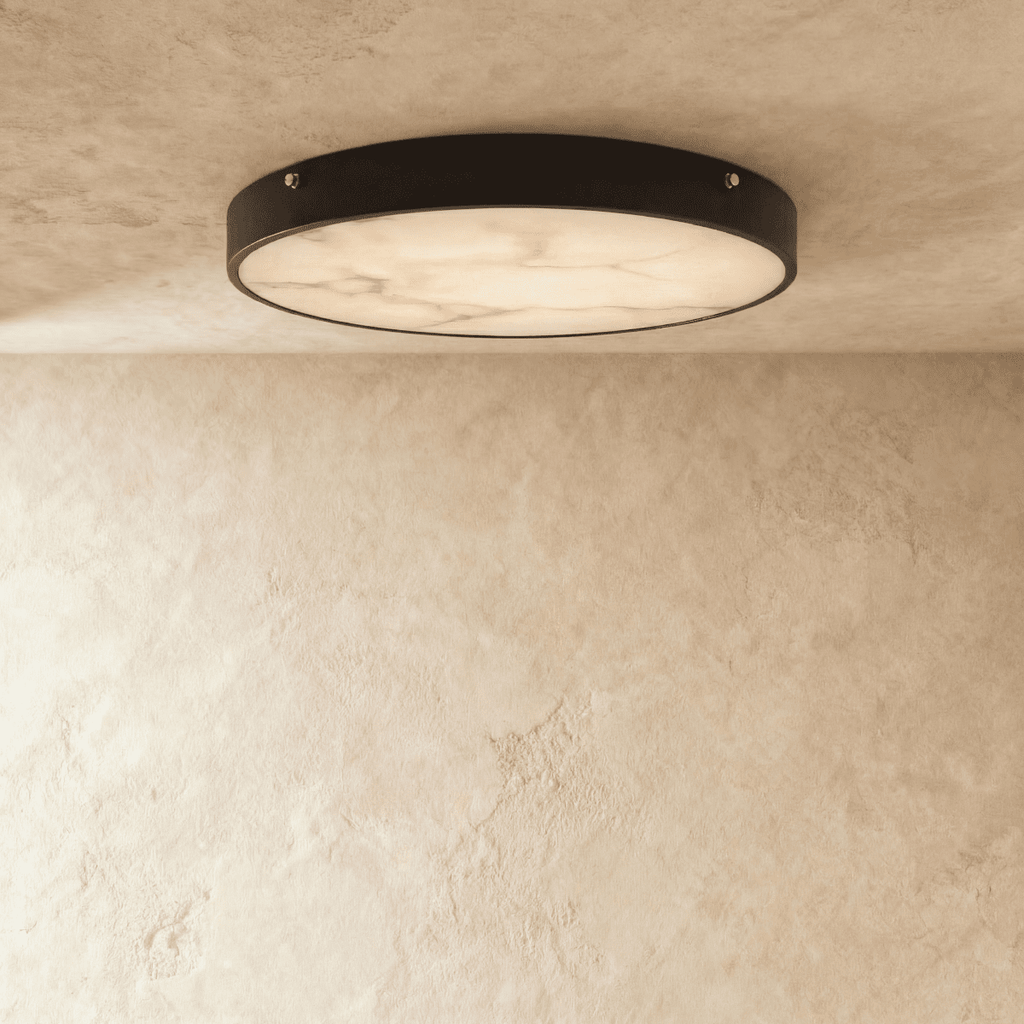 Clérachic round flush ceiling light, lit, with soft marble veining across the diffuser inside a thin dark rim.