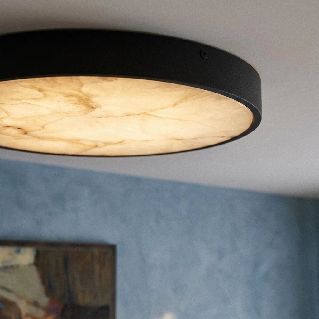 Close view of the Clérachic ceiling light's glowing marble diffuser, with its natural veining and a matte black rim.