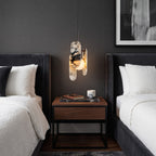 A Clérachic marble pendant glows between two beds with white bouclé bedding, above a walnut bedside table.
