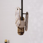 Close view of the metal arms that hold the cream marble panels and the frosted globe on this Clérachic pendant.