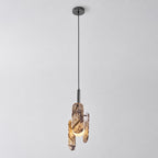 The Clérachic pendant in a cream marble version with violet veining, hung from a black cord and canopy on a pale backdrop.