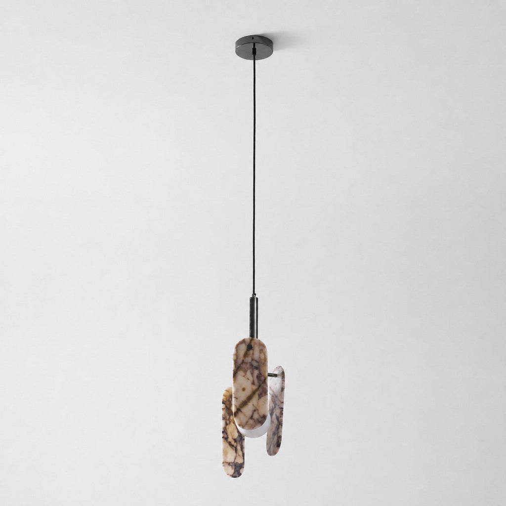 A cream marble version of this Clérachic pendant on a black cord and round black canopy, with its globe softly lit.
