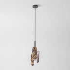 A cream marble version of this Clérachic pendant on a black cord and round black canopy, with its globe softly lit.