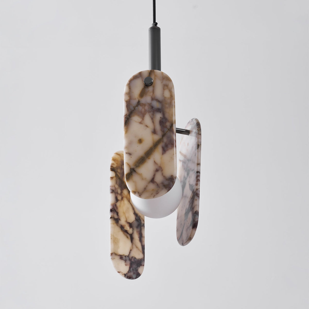 Three-quarter view of a cream marble Clérachic pendant on a black stem, with its frosted globe visible below the panels.