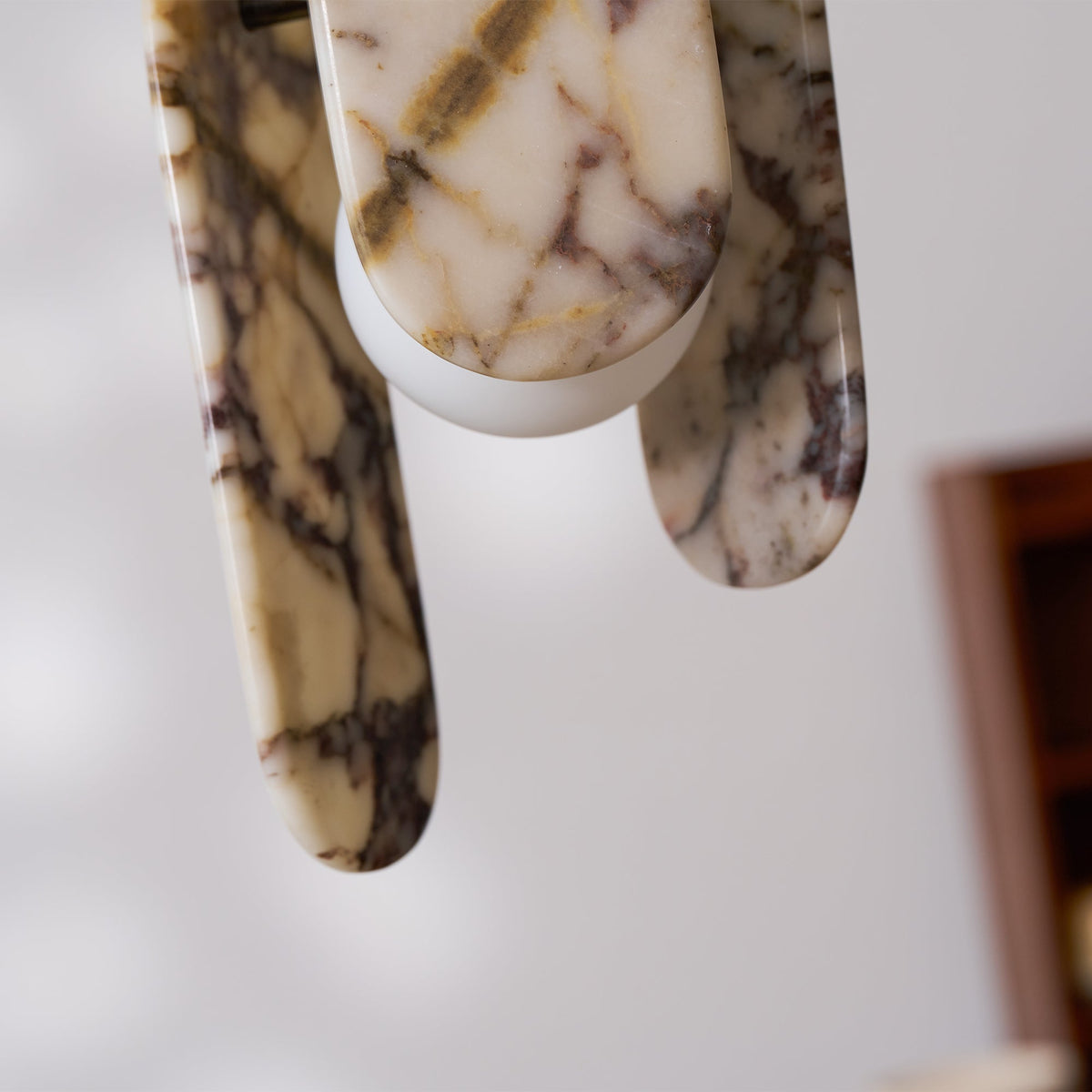 Close view of the oval stone panels and frosted globe on this Clérachic pendant, in cream marble with violet veins.