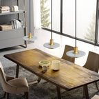 Clérachic row of three white marble and brass pendant lights hung low over a rustic wooden dining table.