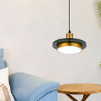 Clérachic dark green marble and brass pendant light with a lit diffuser beside a light blue sofa and wooden side table.