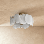 Clérachic semi-flush ceiling light with raw-edged white alabaster slabs around a brass canopy, unlit, on a limewashed ceiling.