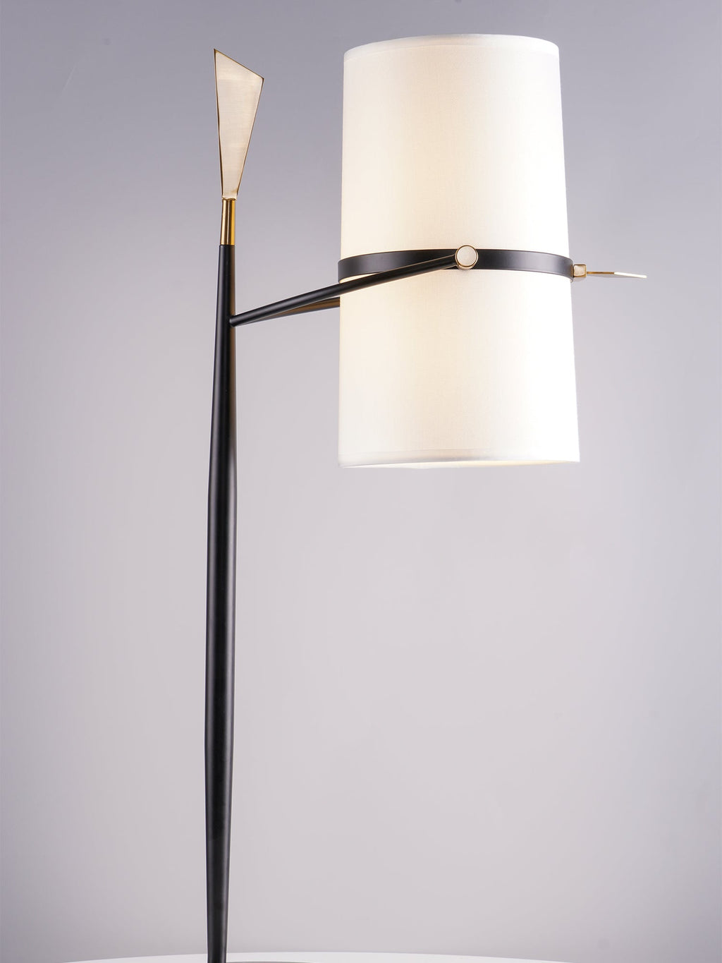 Cropped view of this Clérachic lamp's upright shade, black stem and gold arrow tip against a grey studio backdrop.