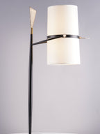 Cropped view of this Clérachic lamp's upright shade, black stem and gold arrow tip against a grey studio backdrop.