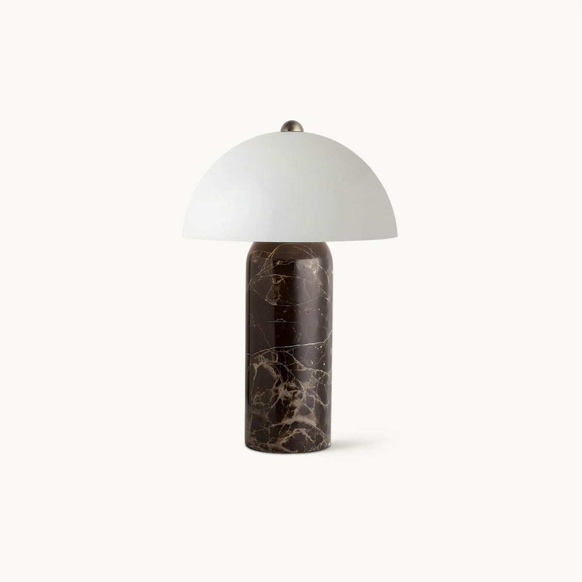 This Clérachic table lamp on a plain white backdrop, with a domed white glass shade above a dark brown veined marble base.