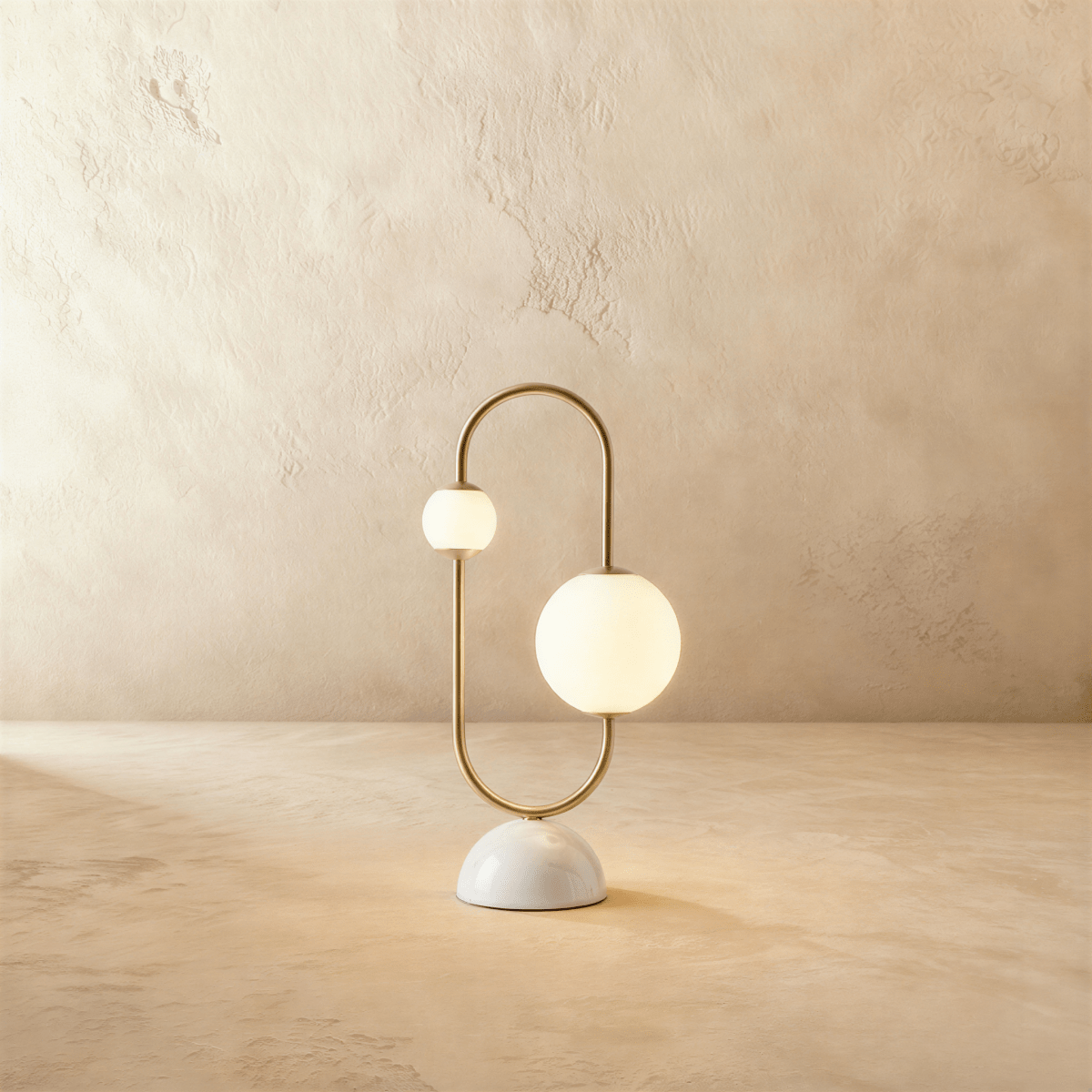 Clérachic table lamp with two opal glass globes on a brass arc over a rounded marble base, unlit.