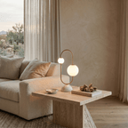 Clérachic table lamp glowing on a stone side table beside a sofa, with a desert view through the window.