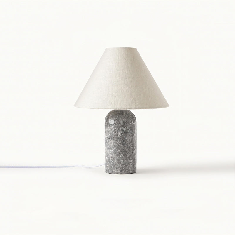 Grey marble base and a pale linen cone shade on this Clérachic table lamp, with its white cord running across the white backdrop.