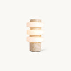 Front view of this Clérachic table lamp on a plain white backdrop, three frosted white glass discs stacked on a beige travertine column.