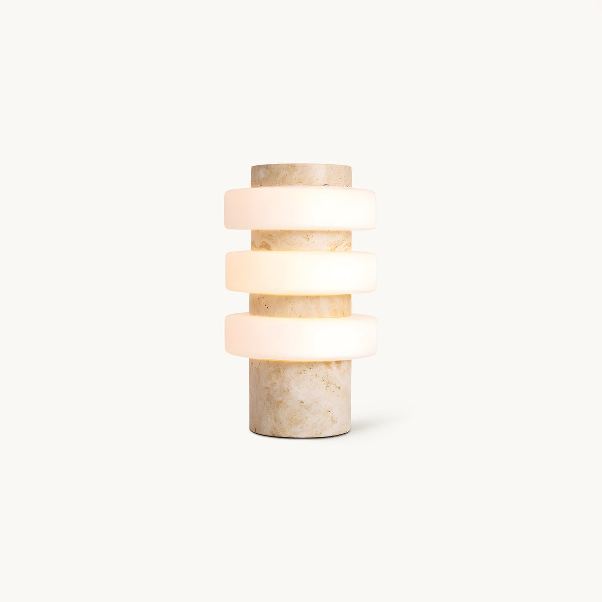 Front view of this Clérachic table lamp on a plain white backdrop, three frosted white glass discs stacked on a beige travertine column.