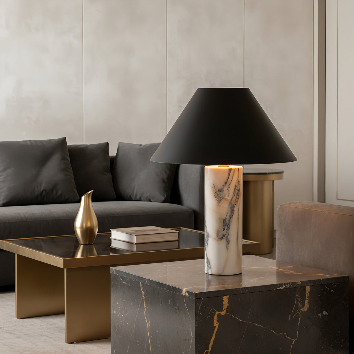 Marble-based Clérachic table lamp on a dark stone side table, with a brass coffee table and grey sofa behind it.