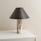 Front view of a Clérachic table lamp, unlit, showing the grey-veined cream marble column under a wide tapered shade.