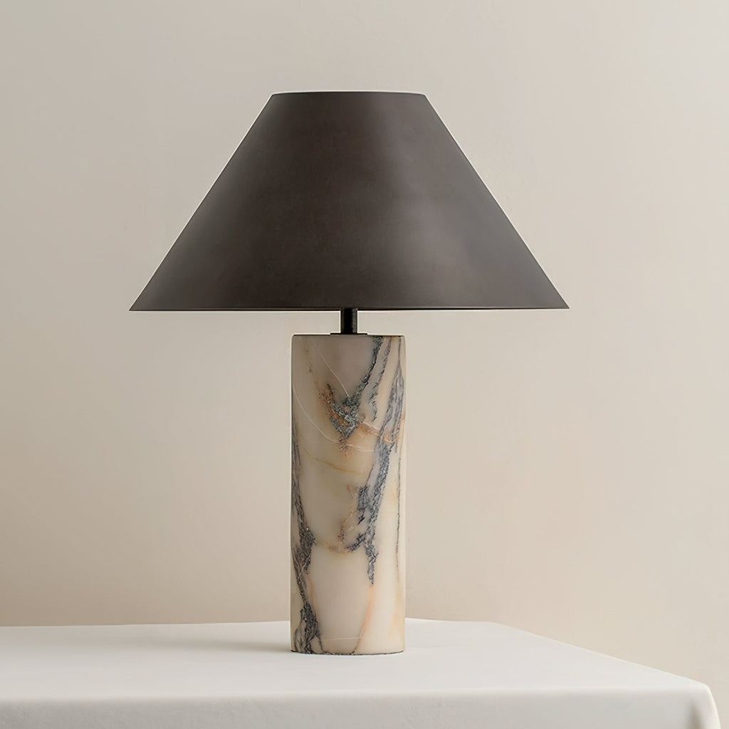 This Clérachic marble lamp, switched off, stands centred on a white table, its black shade tapering from a narrow top to a wide rim.