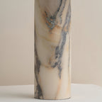 Close view of the marble column on this Clérachic table lamp, showing blue-grey veins running through cream and amber stone.