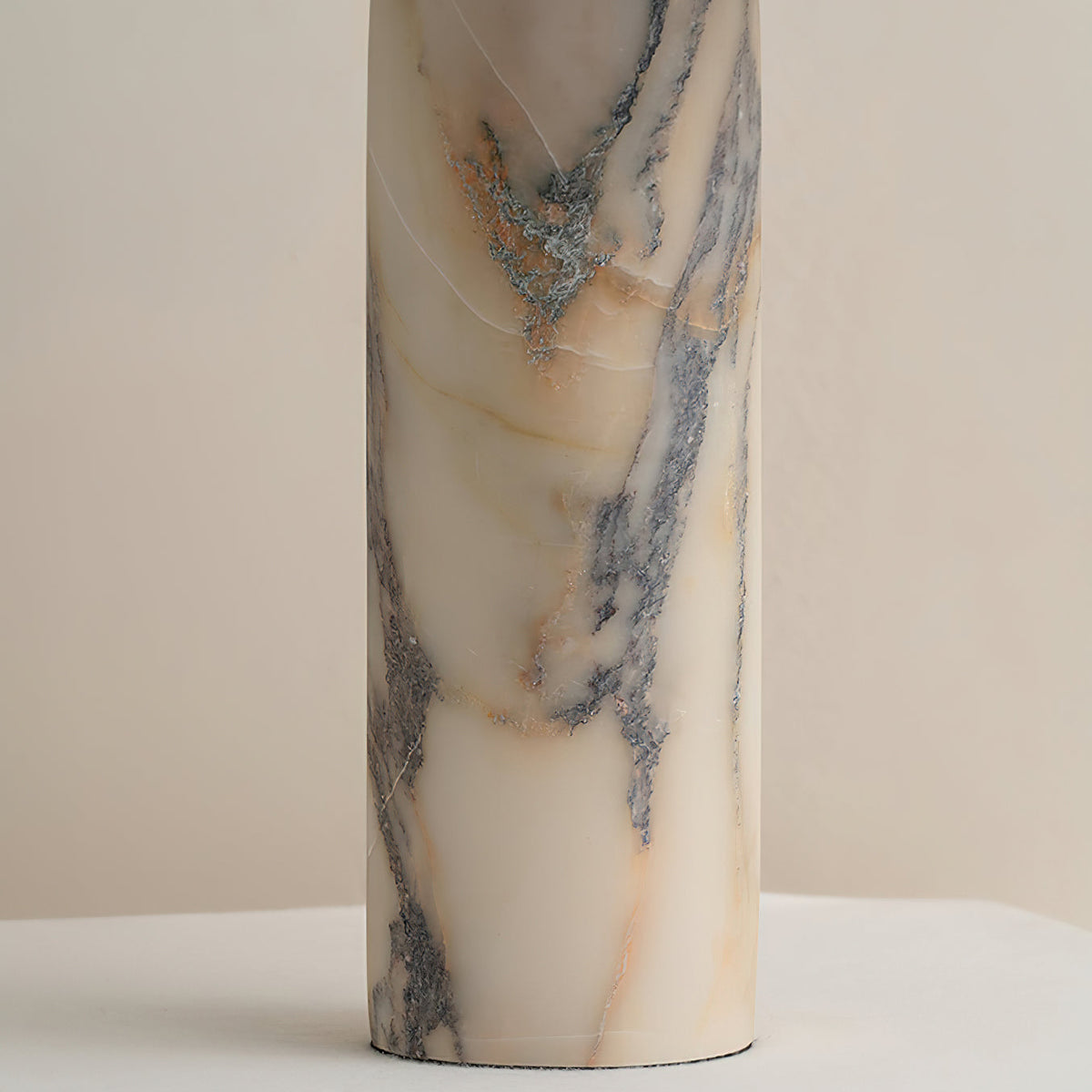 Close view of the marble column on this Clérachic table lamp, showing blue-grey veins running through cream and amber stone.