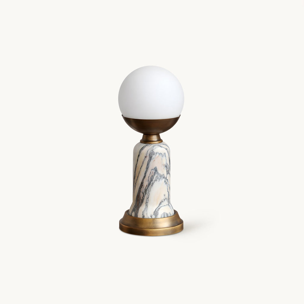 Clérachic table lamp with a white globe shade, a bronze-toned cup and base, and a grey-veined marble stem, on a plain white backdrop.