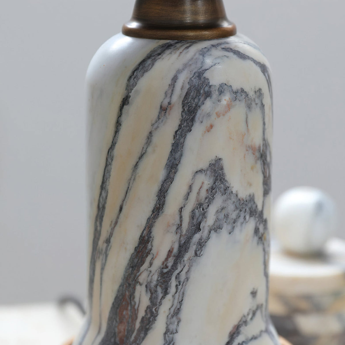Close view of the grey and cream veining on the marble stem of this Clérachic table lamp.