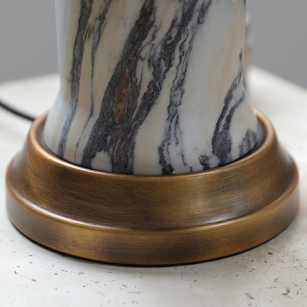 Close view of the marble stem meeting its brushed bronze base on this Clérachic table lamp, with the cord leaving at the back.