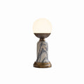 A Clérachic table lamp with a white globe, bronze cup, grey-veined marble stem and bronze base, on a pale studio backdrop.