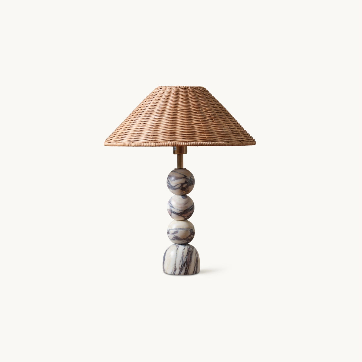 This Clérachic table lamp on a plain white backdrop, with a stacked marble ball base and a wide natural rattan shade.