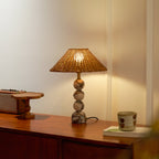 Marble-based Clérachic table lamp glowing softly on a wooden sideboard, with a small tray and a cup in the warm light.