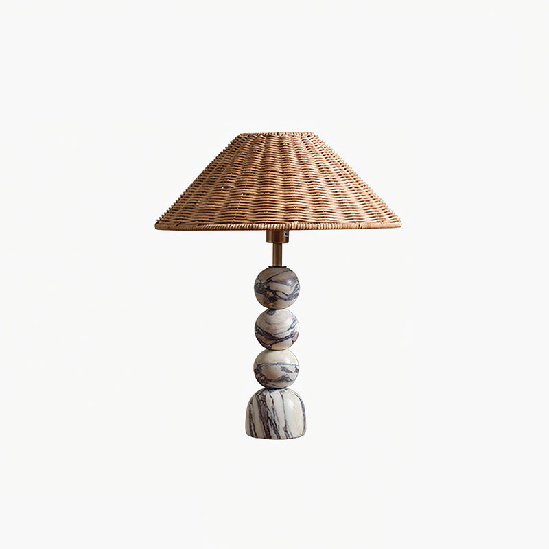 This Clérachic table lamp shown on a white background, with three marble spheres on a rounded foot under a rattan shade.