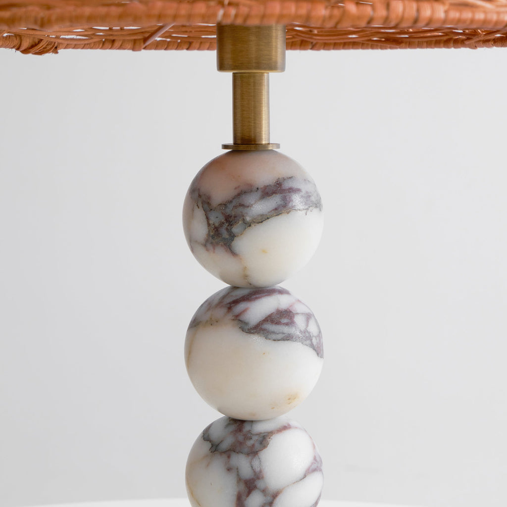 Close view of the brass stem joining the rattan shade to the veined marble spheres of this Clérachic lamp.