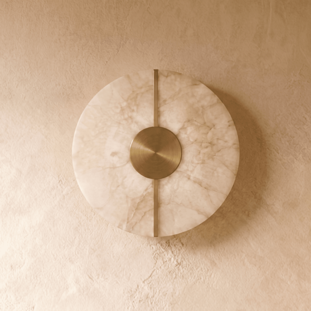 Straight-on view of the Clérachic round alabaster sconce shows its veined stone face lit from behind by warm light.