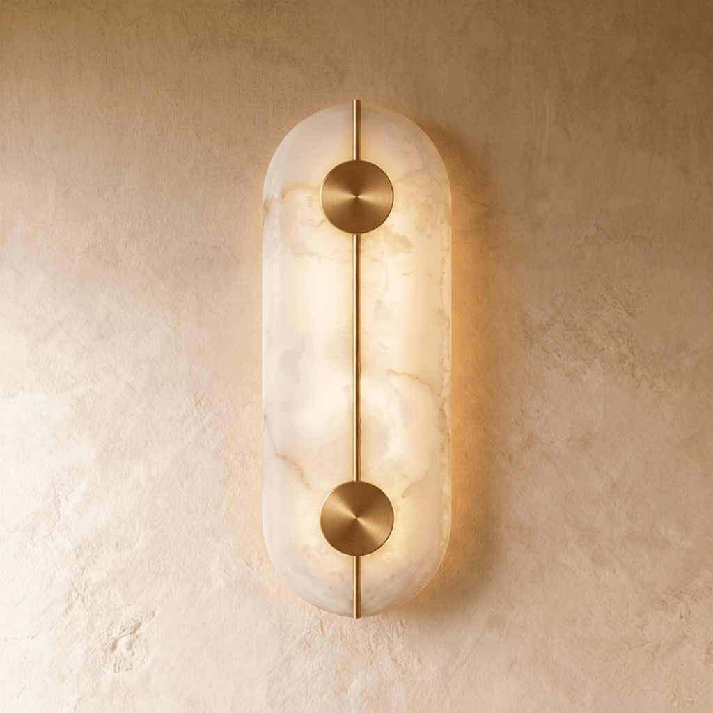 This elongated Clérachic alabaster sconce glows along its capsule shape, brass discs marking two light points.